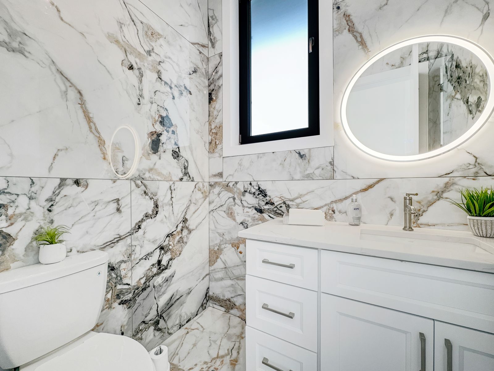 Marble-look vanity with backlit mirror in a completed Carnaby home